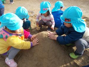 2歳児　砂場で山をつくっています