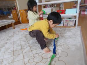 2歳児　ボタンはめの玩具で遊んでいます