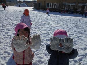 手袋についた雪を見せる子ども