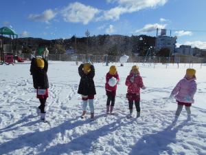 丸めた雪を見せている5歳児