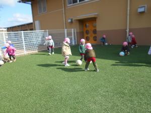 3歳児が友達とボールを蹴り合っています