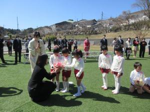 園長先生に子ども達がお花を渡しています