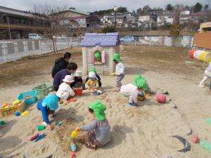 1歳児が砂場で遊んでいます