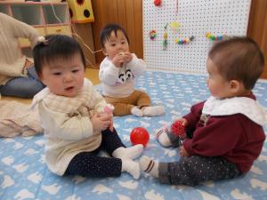 ０歳児のお友だちがお座りして遊んでいます。