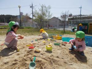 2歳児が砂場で遊んでいます