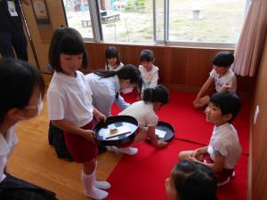 お饅頭を運んでいる子供