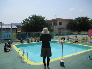 プール開きで園長先生の話を聞く