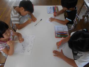 子どもが紙に海の生き物の絵を描いている