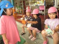 5歳児が4歳児にケーキを食べてもらっています
