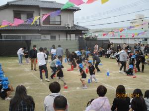 保護者と一緒にペットボトルを倒したり起こしたりしている。