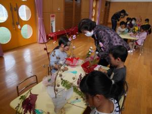 地域の人と一緒に生け花をする子ども達