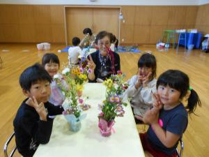 生け花と一緒にグループ写真をとっている