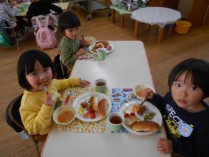 3歳児が友達と一緒に給食を食べています