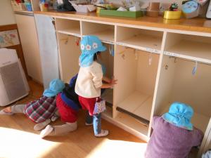 ロッカーの拭き掃除をする3歳児の子ども