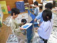 ５歳児ダンボールに色を塗っています