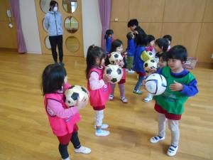 3歳児がサッカーボールを持っています