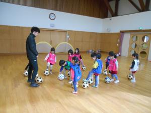 3歳児がサッカーボールを足で止めています