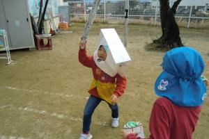 園庭で豆まき遊びをする5歳児