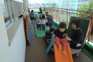 鉄棒にぶら下がる1歳児