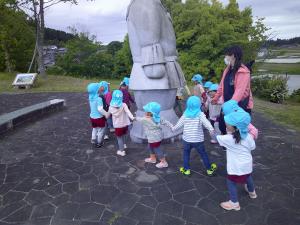 つげまろくんの回りを手をつないで回っている子供