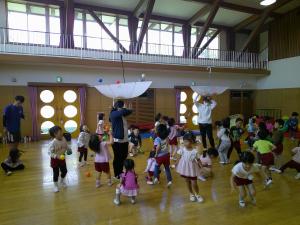 4,5歳児が先生の持っている傘に向かって玉入れをしています