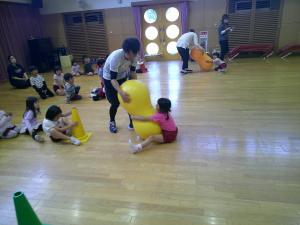 4,5歳児がピーナツボールで先生に引っ張ってもらっています