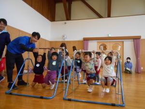 3歳児が鉄棒をぶらさがっています