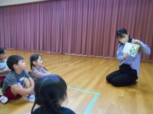 3歳児が先生に絵本を読んでもらっています