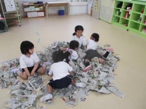 新聞紙の中に隠れようとしています
