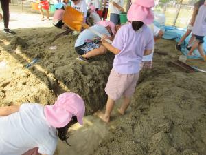 5歳児園庭砂場での水遊びの様子