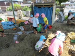 5歳児園庭砂場での川づくりの様子