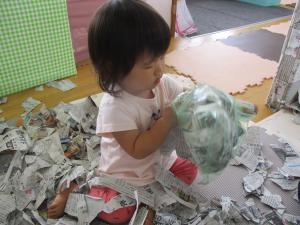 新聞紙を袋に入れている子ども