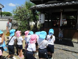 神社でお参りする子供たち