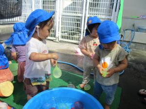 子どもが水風船を持っている。