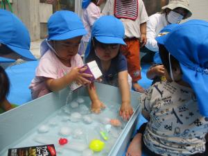 子どもが氷を触っている。
