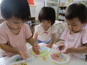 色の付いた寒天を触る子ども達