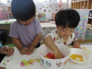 器に入った寒天を触っている子ども達