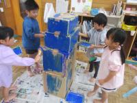 段ボールに絵の具を塗っています