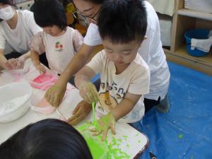 色がついた片栗粉を触っている子ども