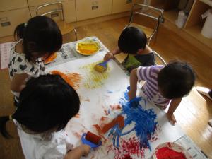 白い紙にローラーで模様をつけている子ども達