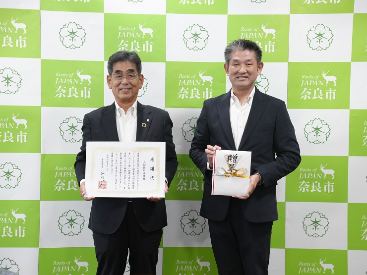 目録と感謝状を交換し終わった理事長と市長の写真