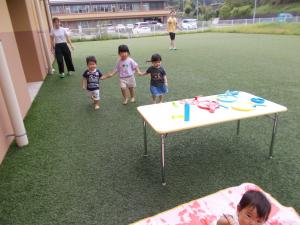 芝生でお友達と手をつないでかけっこ