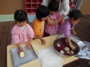 3歳児　さつまいもを包んでいます
