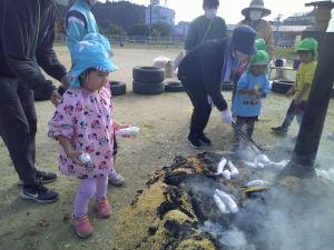 ４歳児　さつまいもを火の中へ入れています