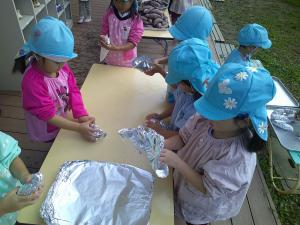 ４歳児　サツマイモを包んでいます