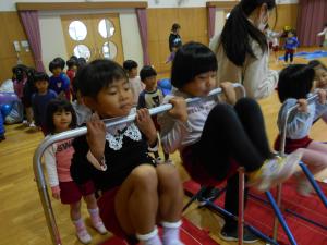 腕に力を入れて鉄棒にぶら下がる子ども達