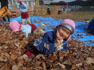 落ち葉に埋まる5歳児