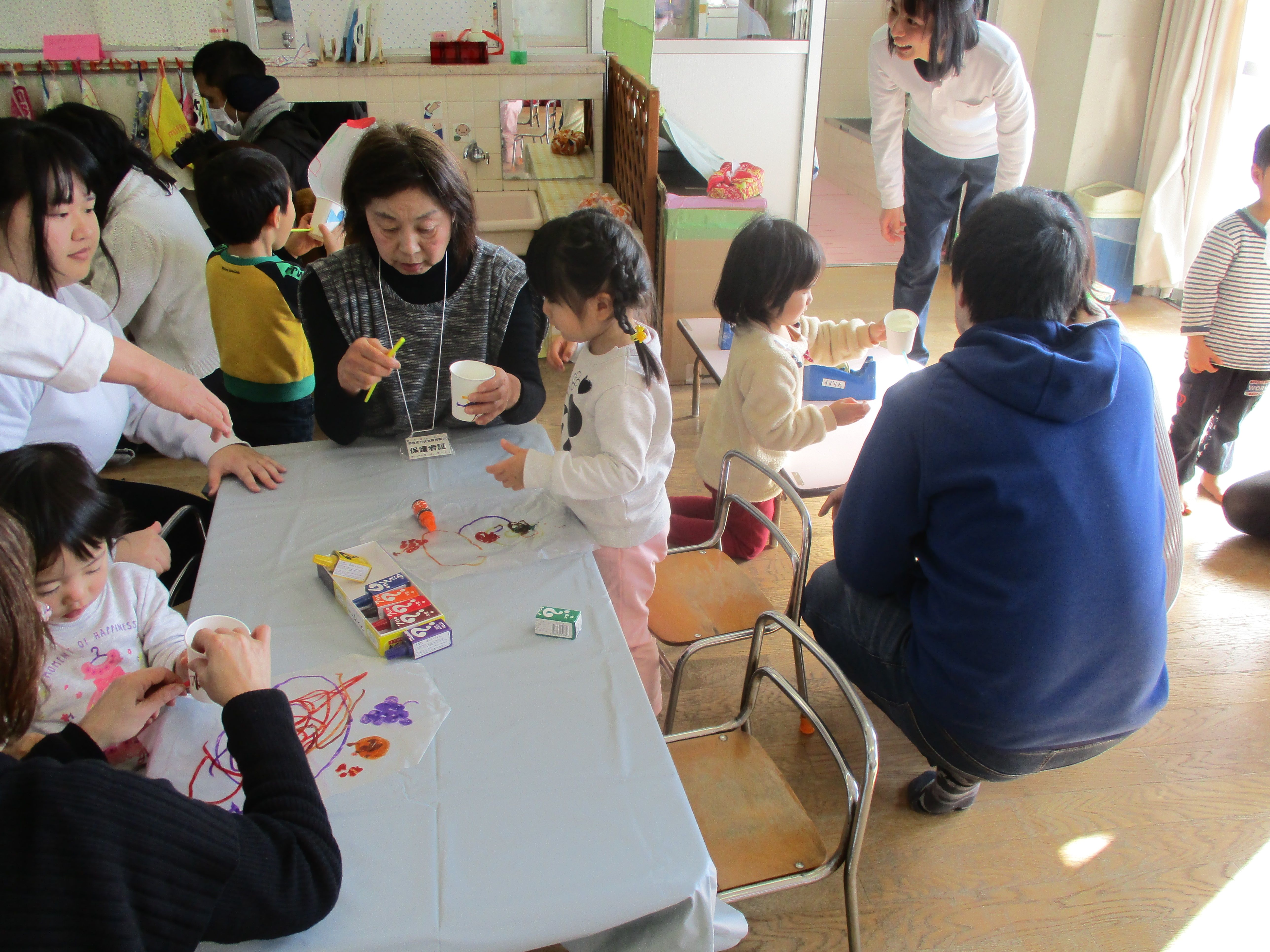 おうちの人と一緒に手作り玩具を作っている2歳児