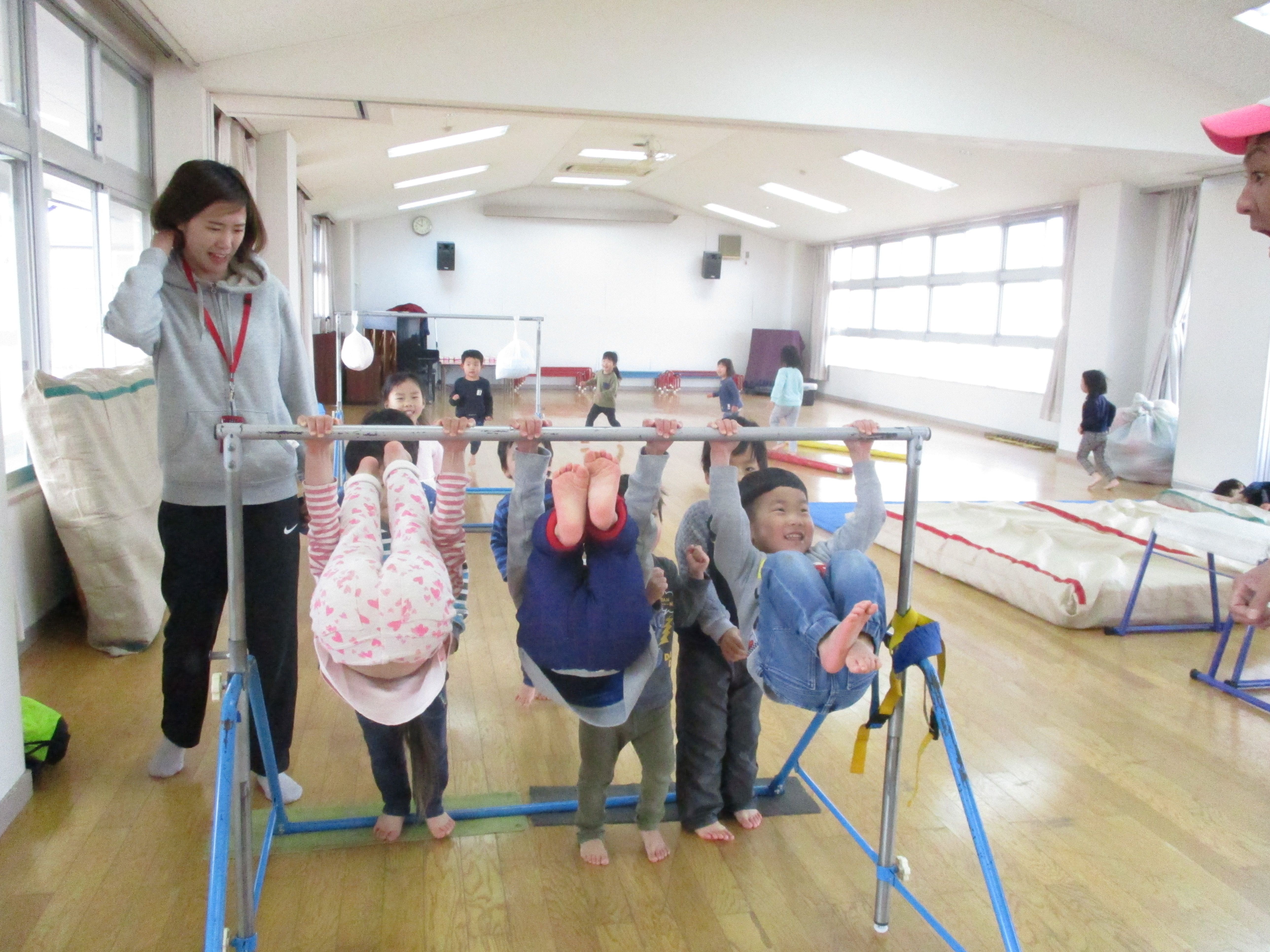 鉄棒にぶら下がる3歳児