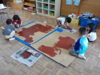 ダンボールに絵の具を塗っています